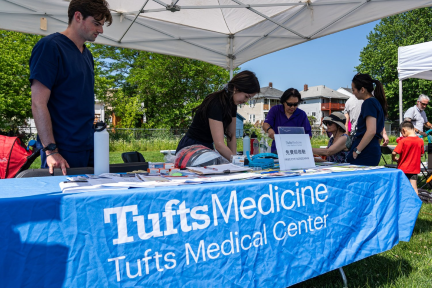 At the outdoor Family Fun Fair in Quincy, volunteers at the Tufts Medical Center tent work together to serve attendees.
